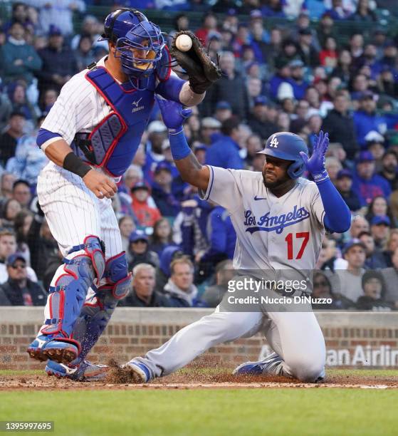 Hanser Alberto of the Los Angeles Dodgers is safe at home against Yan Gomes of the Chicago Cubs during the second inning of Game Two of a...