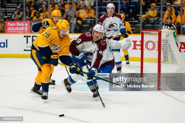 Eeli Tolvanen of the Nashville Predators and Samuel Girard of the Colorado Avalanche fight for the puck during the third period of game three of the...