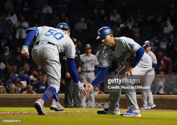 Mookie Betts of the Los Angeles Dodgers is congratulated by third base coach Dino Ebel of the Los Angeles Dodgers following a home run during the...