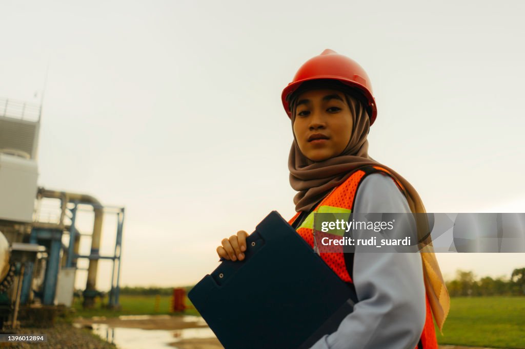 Portrait of young beautiful engineer woman working in factory building