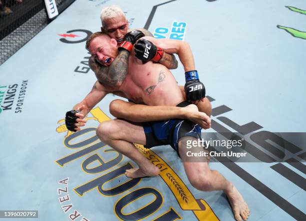 Charles Oliveira of Brazil secures a rear choke submission against Justin Gaethje in the UFC lightweight championship fight during the UFC 274 event...