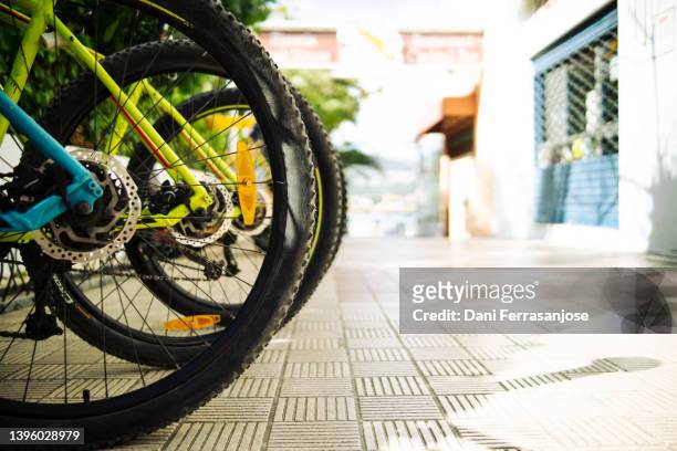 rear wheels of bicycles parked in a public parking lot - bike pedal stock pictures, royalty-free photos & images