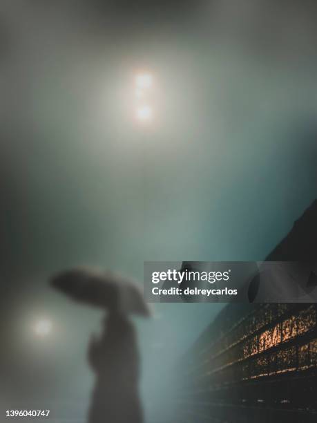 person silhouette on a road with fog at night. - spooky street stock pictures, royalty-free photos & images