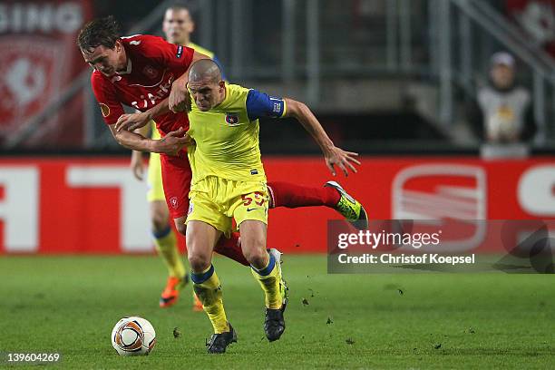 Luuk De Jong of Enschede challenges Alexandru Bourceanu of Steaua Bucuresti during the UEFA Europa League Round of 32 match between FC Twentde and FC...