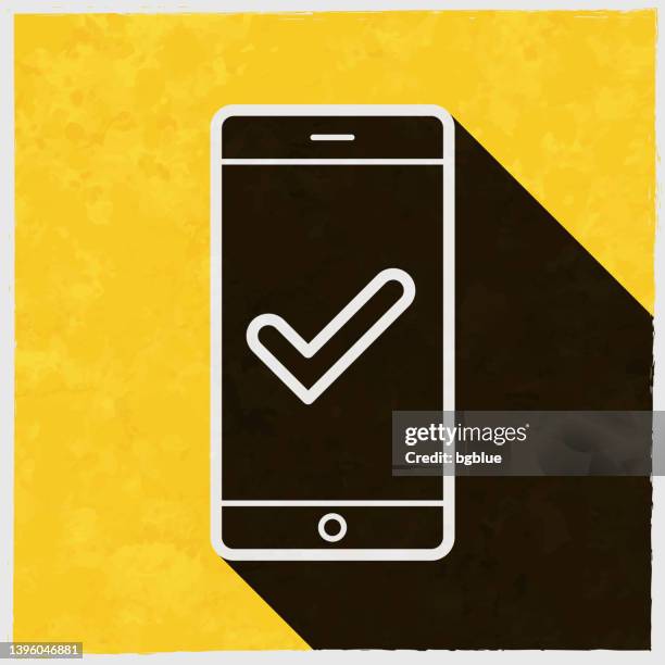 smartphone with check mark. icon with long shadow on textured yellow background - iphone notification stock illustrations