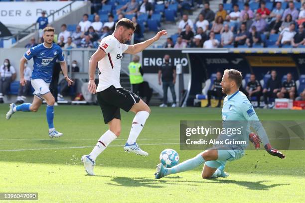 Lucas Alario of Bayer 04 Leverkusen goes past goalkeeper Oliver Baumann of TSG 1899 Hoffenheim before scoring their sides fourth goal during the...