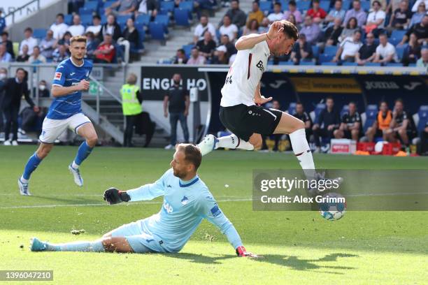 Lucas Alario of Bayer 04 Leverkusen goes past goalkeeper Oliver Baumann of TSG 1899 Hoffenheim before scoring their sides fourth goal during the...