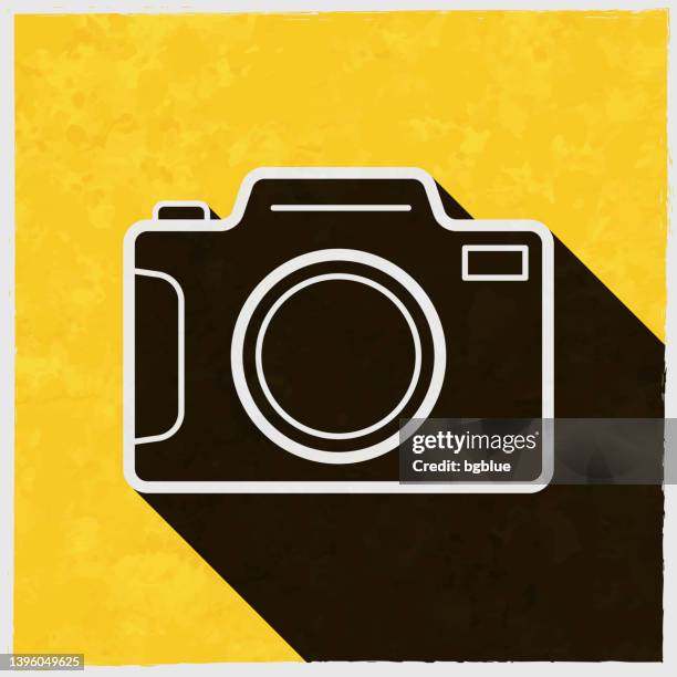 photo camera. icon with long shadow on textured yellow background - old digital camera stock illustrations