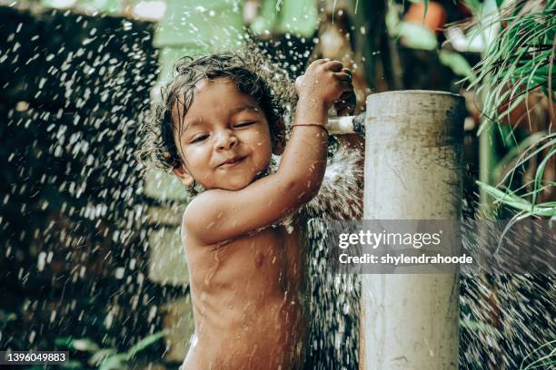 little boy taking bath in tap water - daily life in kerala stock pictures, royalty-free photos & images