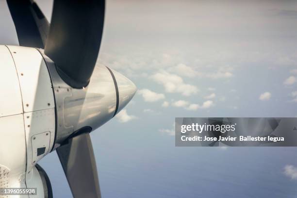 outside view of the airframe of a propeller-driven aircraft in full flight with blue sky background. blur effect - propeller plane stockfoto's en -beelden