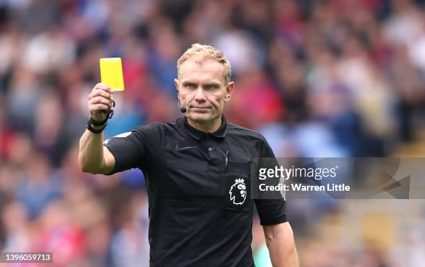 Referee Graham Scott shows a yellow card during the Premier League match between Crystal Palace and Watford at Selhurst Park on May 07, 2022 in...