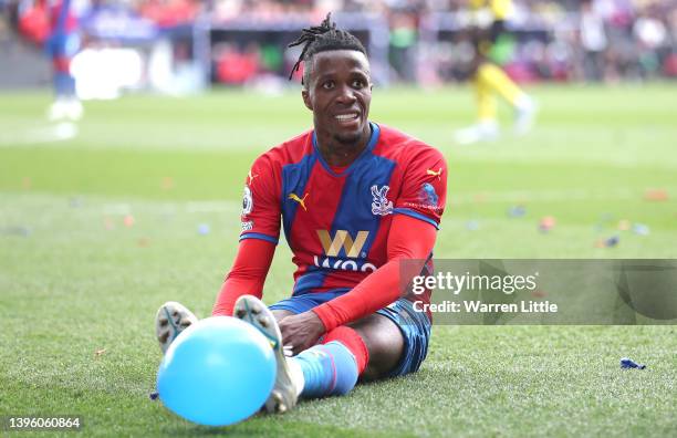 Wilfried Zaha of Crystal Palace sits on pitch after being by Ismaila Sarr of Watfordduring the Premier League match between Crystal Palace and...