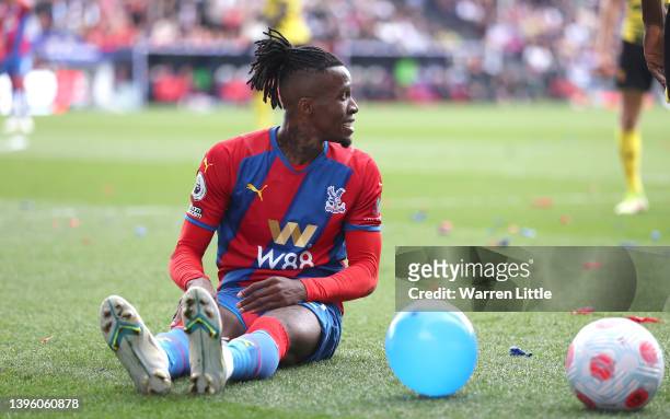 Wilfried Zaha of Crystal Palace sits on pitch after being by Ismaila Sarr of Watfordduring the Premier League match between Crystal Palace and...