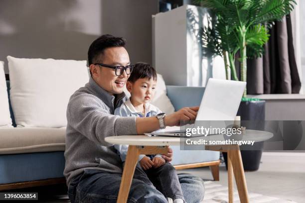 father holding son working on laptop - daddy in chinese stock pictures, royalty-free photos & images
