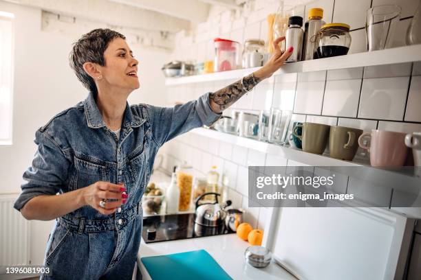 housewife organizing the kitchen. - shelf strip stock pictures, royalty-free photos & images