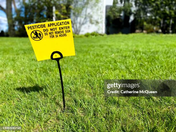 bright yellow pesticide lawn warning sign - pest foto e immagini stock