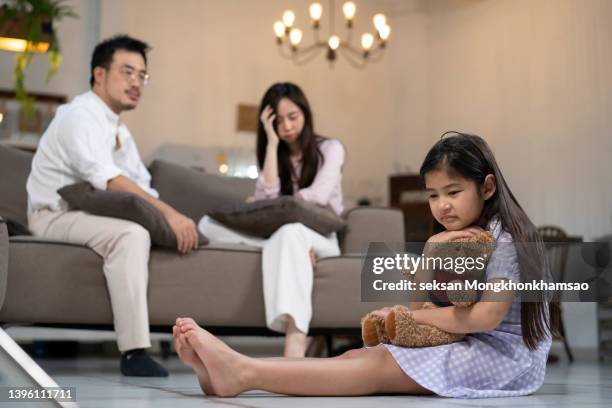 upset little girl cuddling teddy bear, suffering from parents arguing - mama bear - fotografias e filmes do acervo