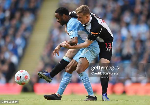 Raheem Sterling of Manchester City is challenged by Matt Targett of Newcastle United during the Premier League match between Manchester City and...