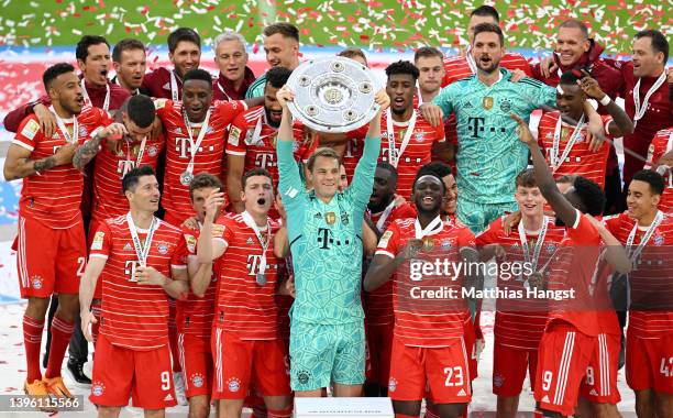 Manuel Neuer of FC Bayern Muenchen lifts The Bundesliga Meisterschale trophy following their sides finish as the Bundesliga champions during the...