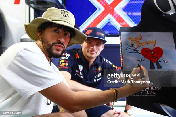 Bad Bunny signs the rear wing of the car of Max Verstappen of the Netherlands and Oracle Red Bull Racing as they pose for a photo during the F1 Grand...