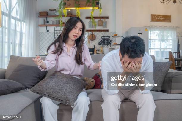 husband and wife arguing at home. - asian couple arguing stockfoto's en -beelden