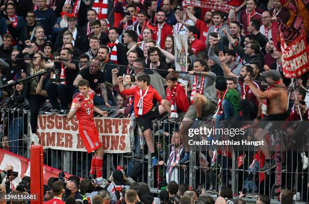 Thomas Mueller of FC Bayern Muenchen celebrates with the fans after their sides victory as Bundesliga champions during the Bundesliga match between...