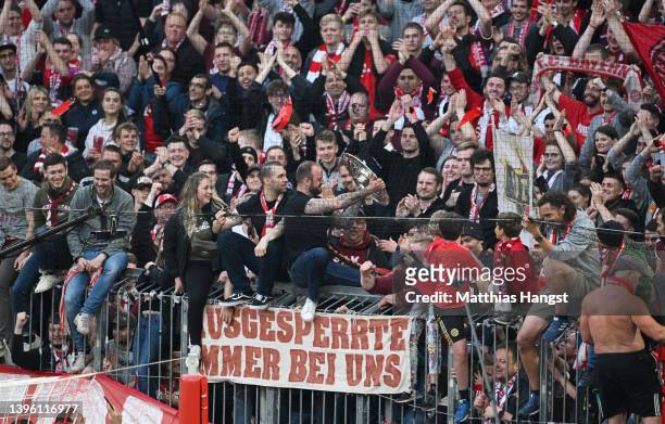 Bayern Muenchen fans celebrate with The Bundesliga Meisterschale trophy after their side finished the season as Bundesliga champions during the...