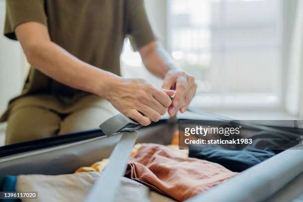 woman packing her suitcase. - open backpack stock pictures, royalty-free photos & images
