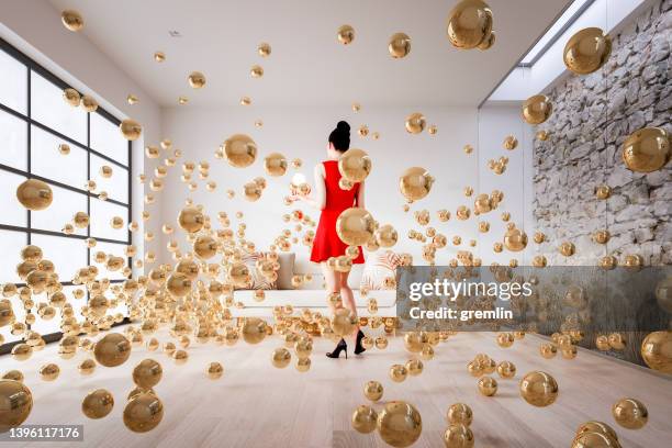 esfera explosiva en la sala de estar con la mujer de pie - gold shoe fotografías e imágenes de stock