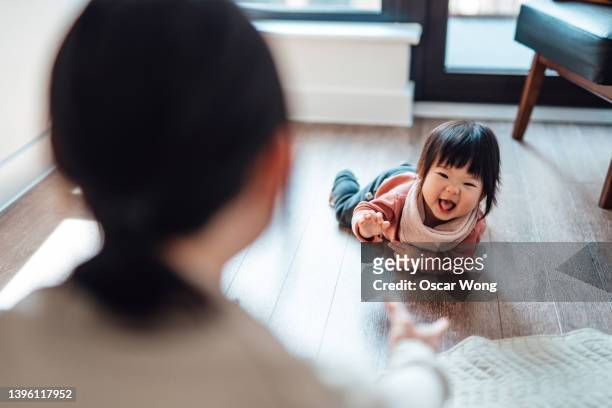 over the should view of mother watching her baby crawling on the floor - 這う ストックフォトと画像