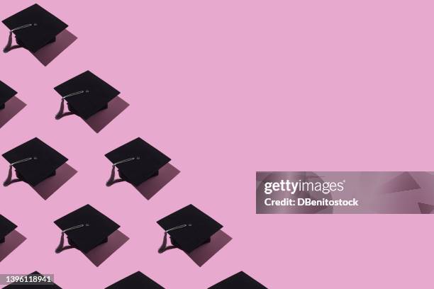 pattern of black graduation caps with gray tassel with hard shadow, on the left side, on pink background. graduation, achievement, goal, degree, master, bachelor, college and success concept. - birrete fotografías e imágenes de stock