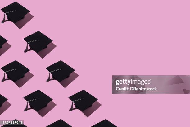 pattern of black graduation caps with gray tassel with hard shadow, on the left side, on pink background. graduation, achievement, goal, degree, master, bachelor, college and success concept. - toque de diplômé photos et images de collection