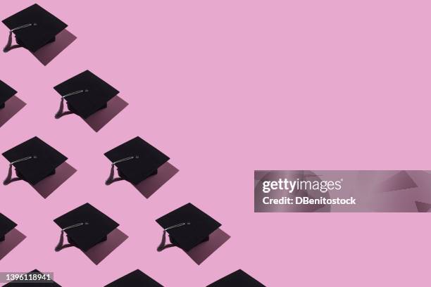 pattern of black graduation caps with gray tassel with hard shadow, on the left side, on pink background. graduation, achievement, goal, degree, master, bachelor, college and success concept. - chapéu de formatura - fotografias e filmes do acervo