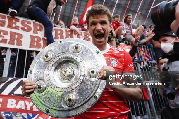 Thomas Mueller of FC Bayern Muenchen lifts The Bundesliga Meisterschale trophy following their sides finish as the Bundesliga champions during the...