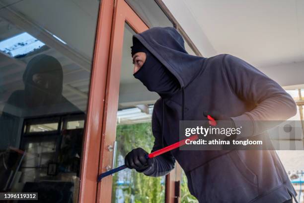 robber breaks house door. - haus einbruch stock-fotos und bilder
