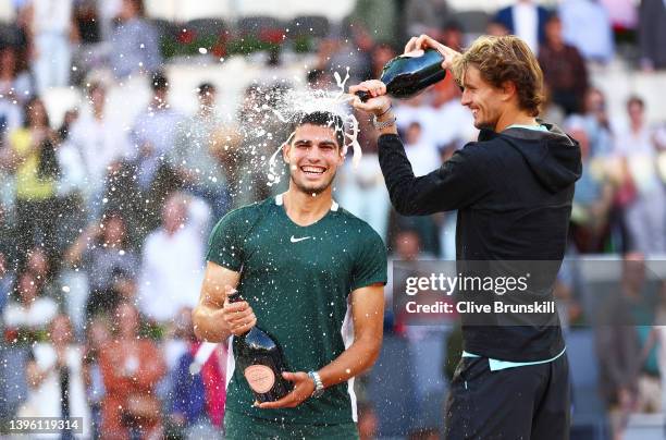Alexander Zverev of Germany pours champagne over and congratulates Carlos Alcaraz Garfia of Spain after the men's singles final match at La Caja...