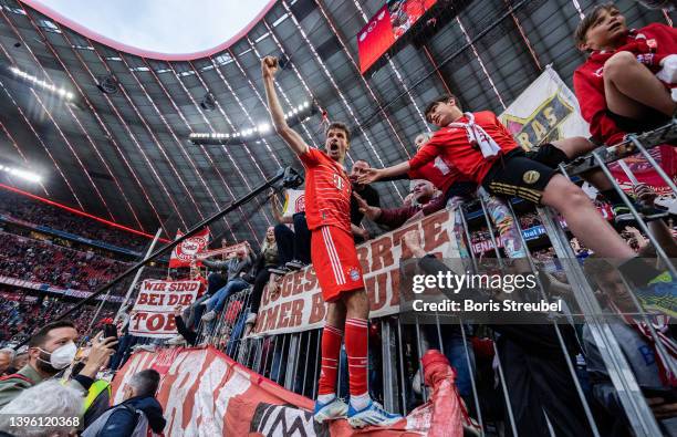 Thomas Mueller of FC Bayern Muenchen celebrates with his fans following their sides finish as Bundesliga champions after the Bundesliga match between...