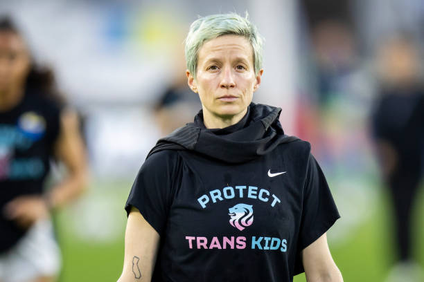 Megan Rapinoe of OL Reign wears a shirt that says Protest Trans Kids while she walks back to locker room after warm ups before the 2022 NWSL...