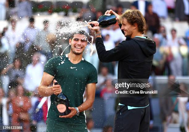 Alexander Zverev of Germany congratulates and pours champagne over Carlos Alcaraz Garfia of Spain after the men's singles final match at La Caja...