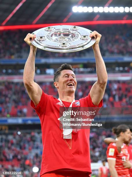 Robert Lewandowski of FC Bayern Muenchen celebrates with the Bundesliga Meisterschale Trophy following victory during the Bundesliga match between FC...