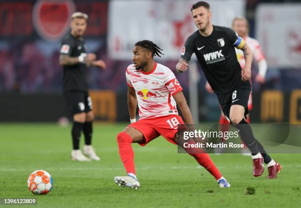 Christopher Nkunku of Red Bull Leipzig is chased by Jeffrey Gouweleeuw of FC Augsburg during the Bundesliga match between RB Leipzig and FC Augsburg...