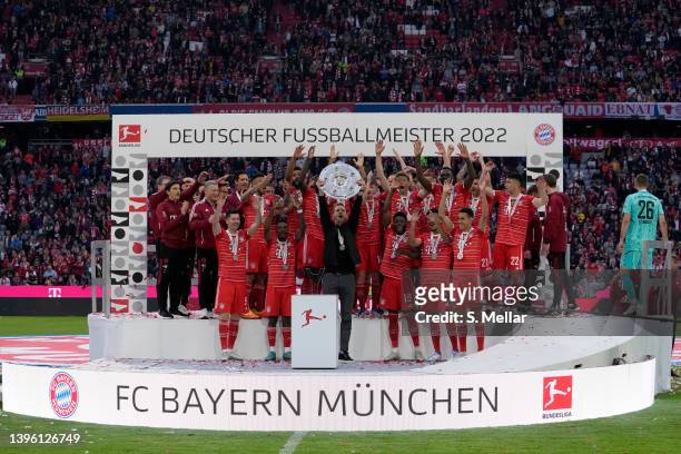 Head coach Julian Nagelsmann of Bayern Muenchen lifts the championship trophy and celebrates winning the championship with his team after the...