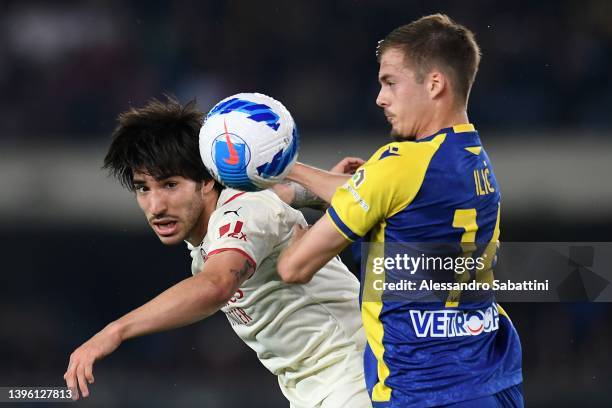 Sandro Tonali of AC Milan competes for the ball with Ivan Ilic of Hellas Verona during the Serie A match between Hellas Verona FC and AC Milan at...