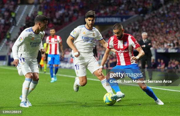 Marco Asensio of Real Madrid challenges Yannick Ferreira Carrasco of Atletico Madrid during the La Liga Santander match between Club Atletico de...