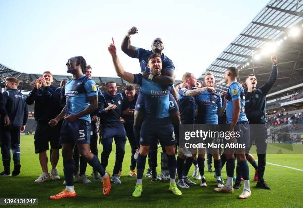 Anthony Stewart, Adebayo Akinfenwa and Ryan Tafazolli of Wycombe Wanderers celebrate progressing to the Sky Bet League One Play-Off Final after...