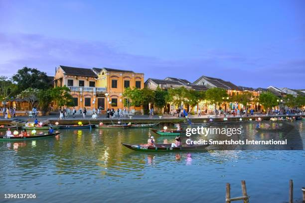 traditional vietnamese gondolas illuminated at early night on thu bon river in hoi an, vietnam - hoi an vietnam stock-fotos und bilder