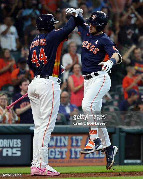 Alex Bregman of the Houston Astros receives congratulations from Yordan Alvarez after hitting a home run in the fifth inning against the Detroit...