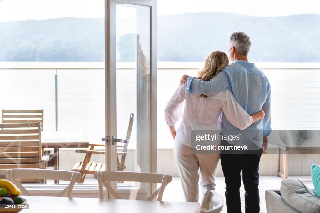 Mature couple looking at the view in their waterfront home
