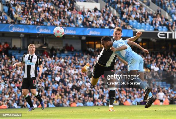 Manchester City player Raheem Sterling beats the challenge of Newcastle defender Dan Burn to head in the opening city goal during the Premier League...