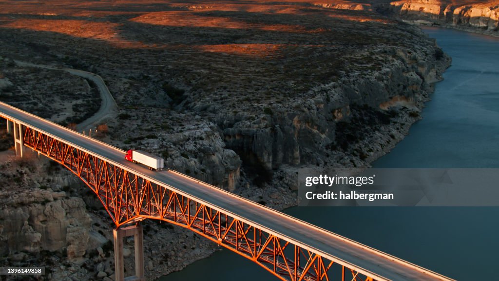 Hochwinkel-Drohnenaufnahme eines Lastwagens, der die Pecos River Bridge überquert